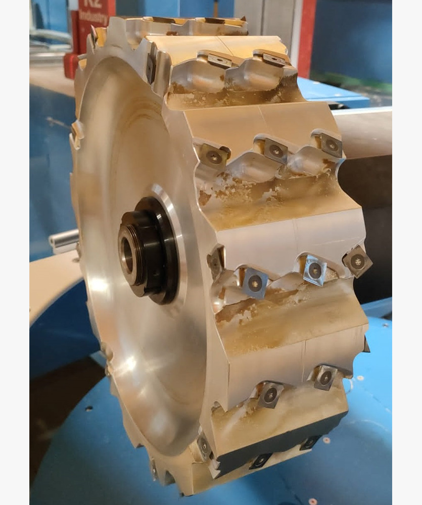 Brown leather key ring with brass metal loops and rivets on wood table.