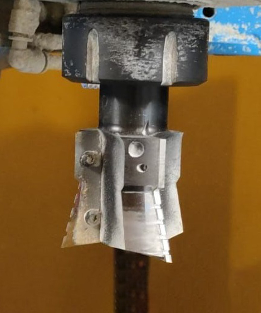 Brown leather key ring with brass metal loops and rivets on wood table.