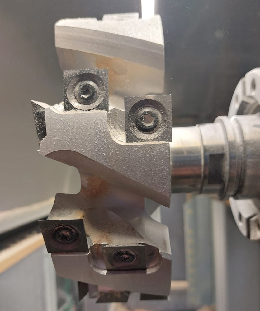 Brown leather key ring with brass metal loops and rivets on wood table.