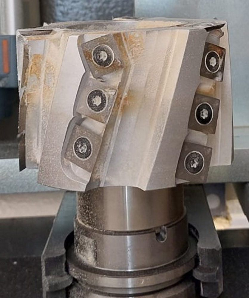 Brown leather key ring with brass metal loops and rivets on wood table.