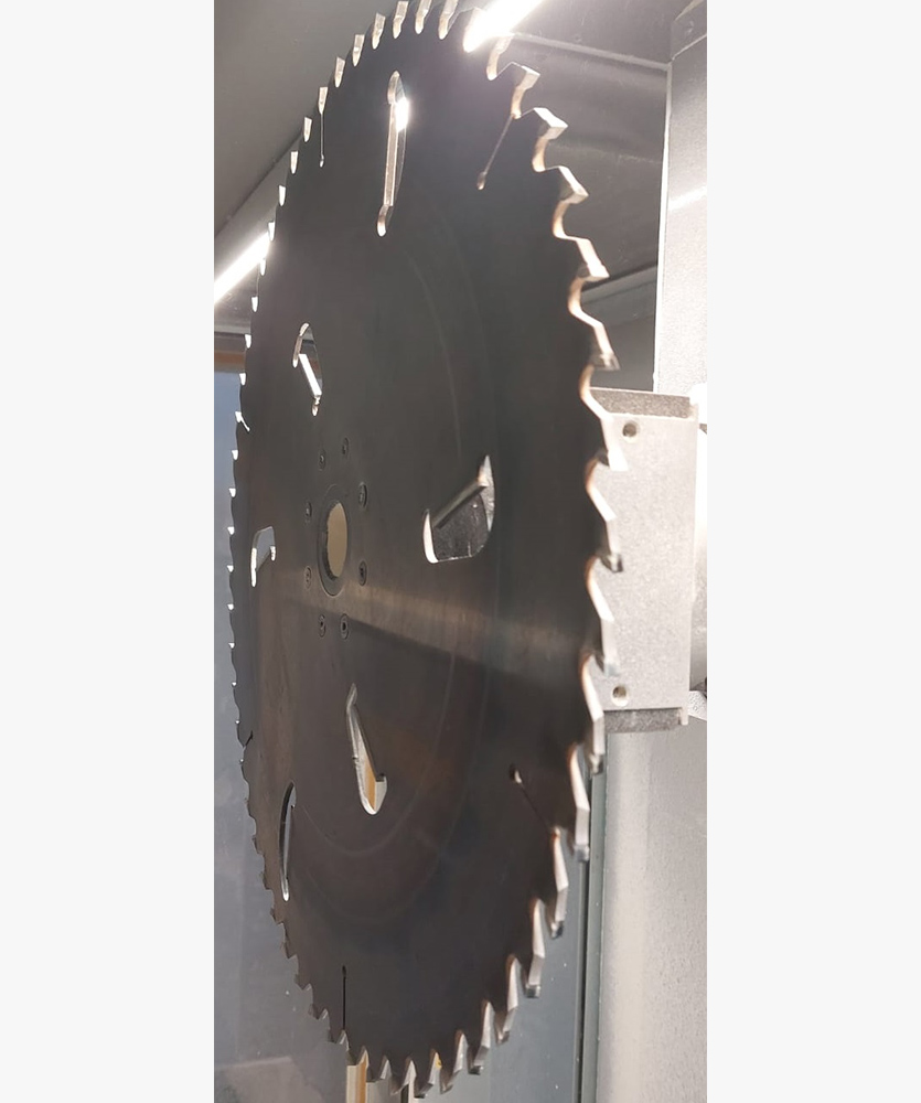 Brown leather key ring with brass metal loops and rivets on wood table.