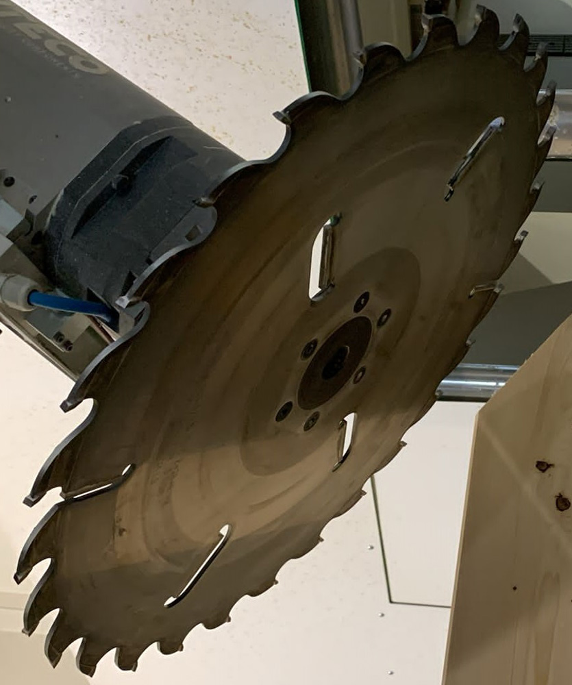 Brown leather key ring with brass metal loops and rivets on wood table.