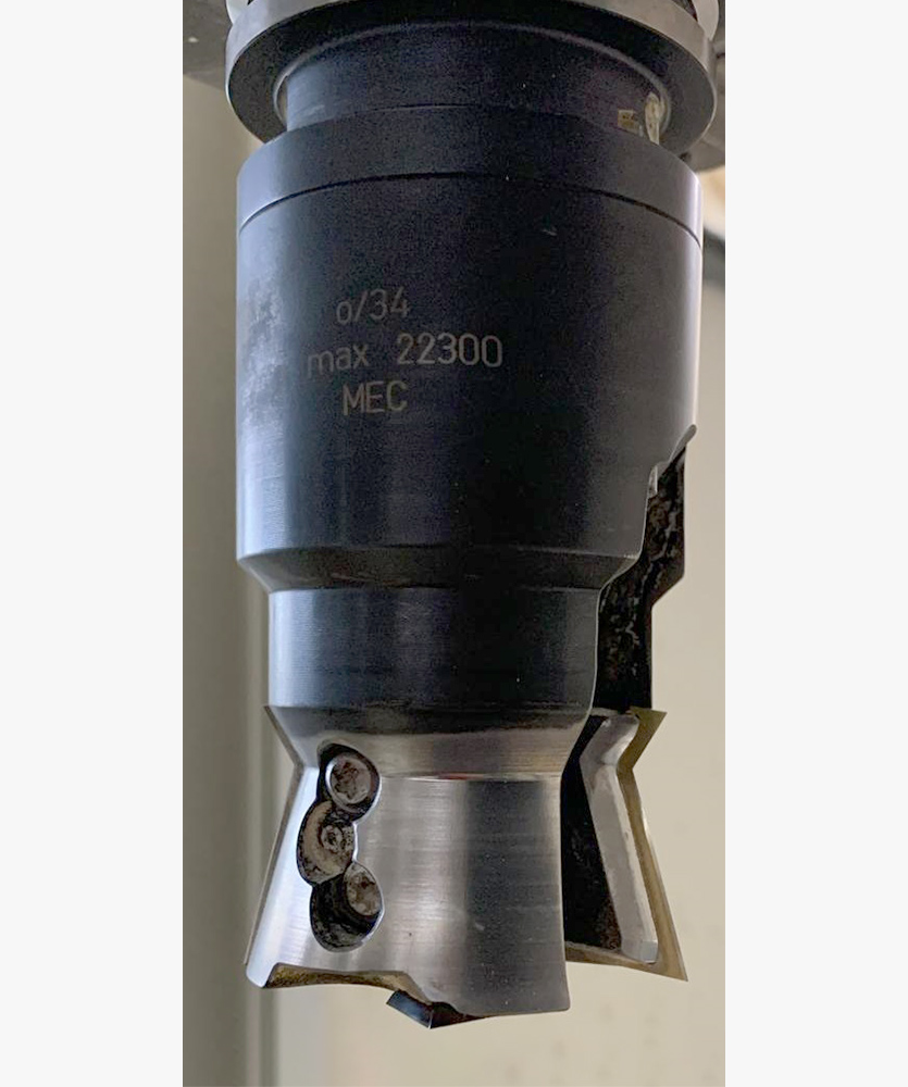 Brown leather key ring with brass metal loops and rivets on wood table.