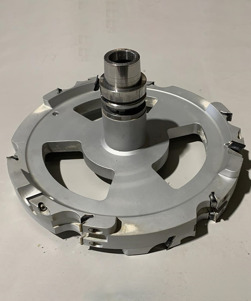 Brown leather key ring with brass metal loops and rivets on wood table.