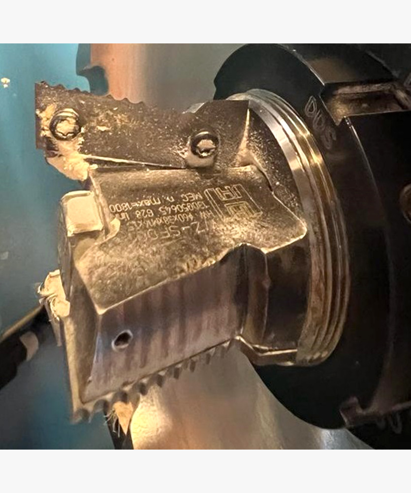 Brown leather key ring with brass metal loops and rivets on wood table.