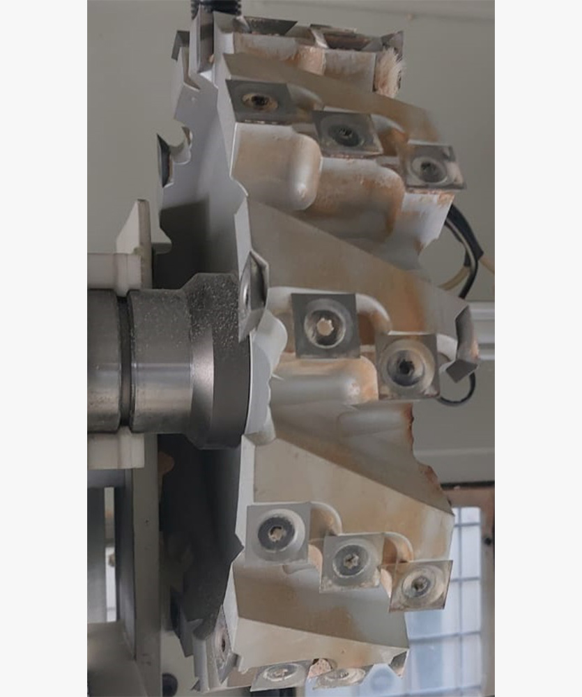 Brown leather key ring with brass metal loops and rivets on wood table.