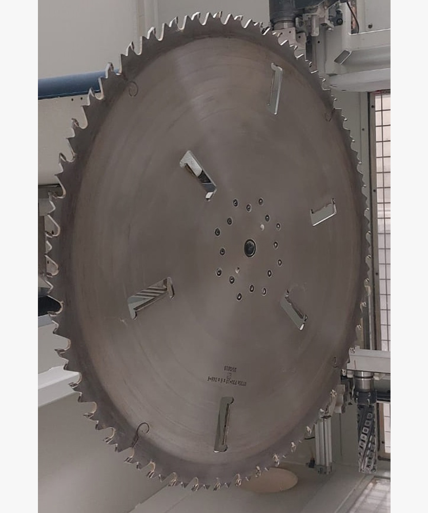 Brown leather key ring with brass metal loops and rivets on wood table.