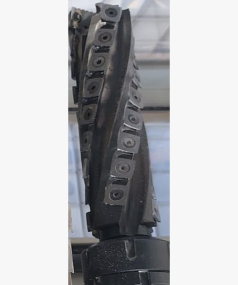 Brown leather key ring with brass metal loops and rivets on wood table.