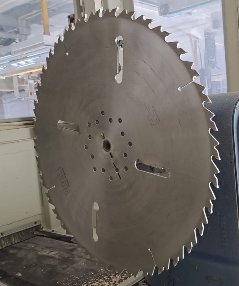 Brown leather key ring with brass metal loops and rivets on wood table.