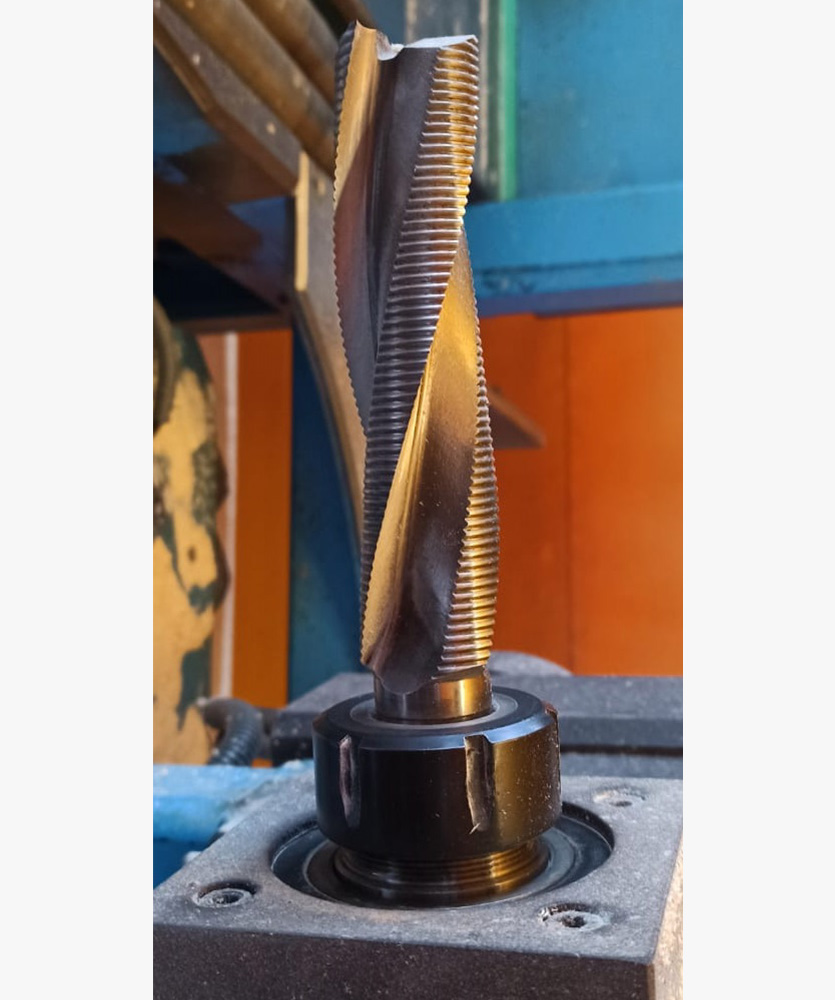 Brown leather key ring with brass metal loops and rivets on wood table.