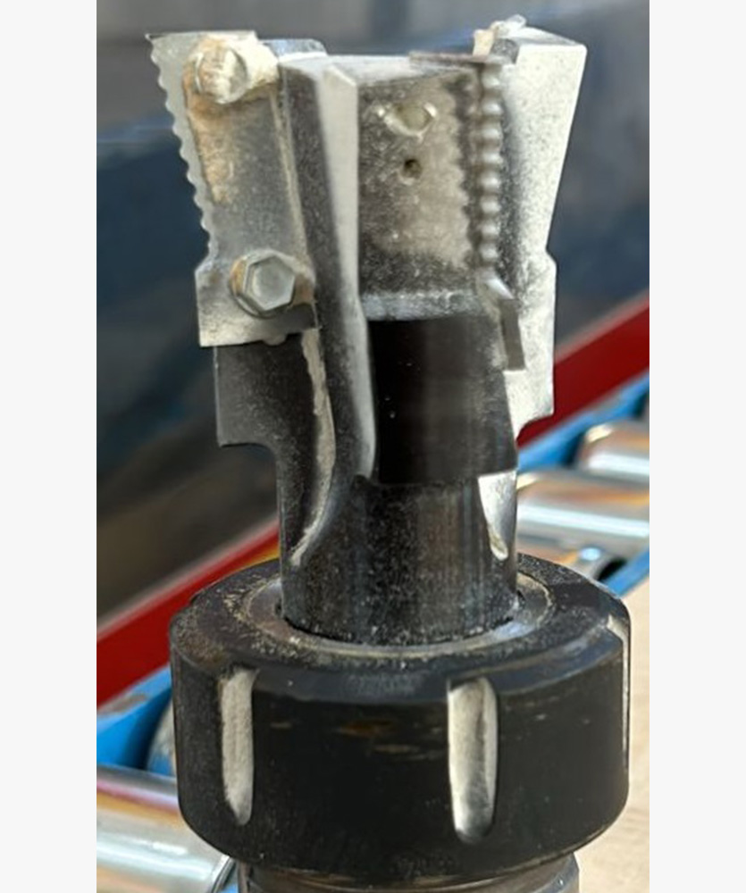 Brown leather key ring with brass metal loops and rivets on wood table.