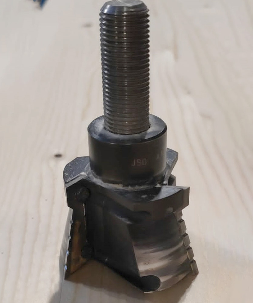 Brown leather key ring with brass metal loops and rivets on wood table.