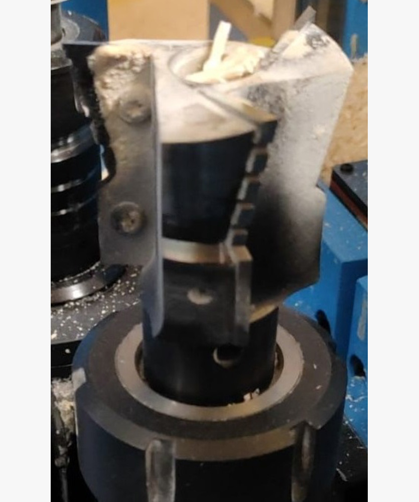 Brown leather key ring with brass metal loops and rivets on wood table.